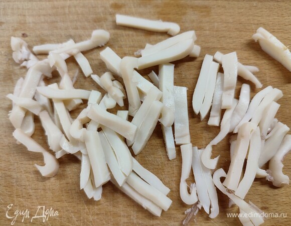 Вареные кальмары нарезать соломкой.