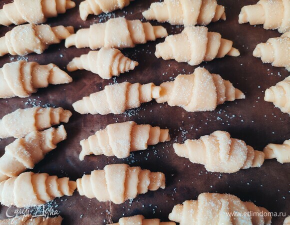 Рогалики хорошо обвалять в сахаре и выложить на противень.