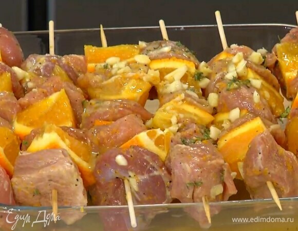 На предварительно вымоченные шпажки нанизать кусочки мяса, чередуя их с апельсином, затем поместить на края формы для выпечки, так чтобы мясо не соприкасалось с формой.