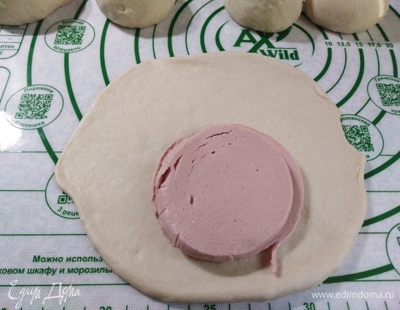 Каждый шарик раскатать. Положить колбасу.