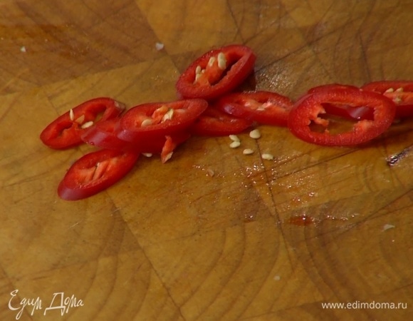 Перец чили нарезать колечками и выложить на салат.