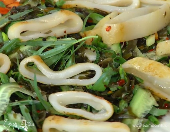 Обжаренные кальмары нарезать тонкими кольцами и украсить ими салат.