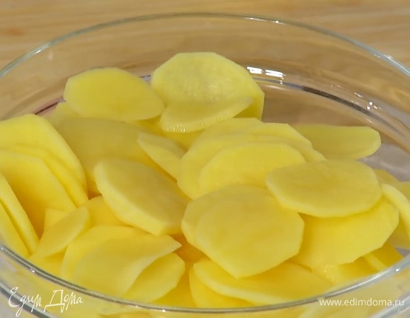 Картофель почистить, нарезать тонкими кружками и замочить, затем воду слить и промокнуть ломтики бумажным полотенцем.