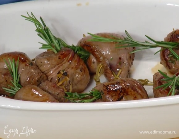 Свернуть ягнятину рулетиками, скрепить зубочистками, выложить в сковороду и обжарить до золотистой корочки, затем переложить в жаропрочную керамическую форму и в каждый рулетик воткнуть веточку розмарина.