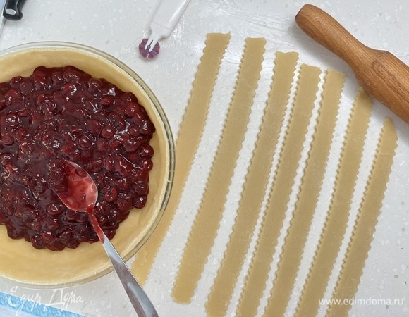 Тесто разделить на 2 части. Из большей раскатать круг и выложить как основу пирога в форму. Выложить на нее начинку. Из меньшей части вырезать полосочки и выложить сверху сеточкой.