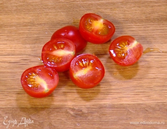 Помидоры черри разрезать пополам и выложить к цукини.