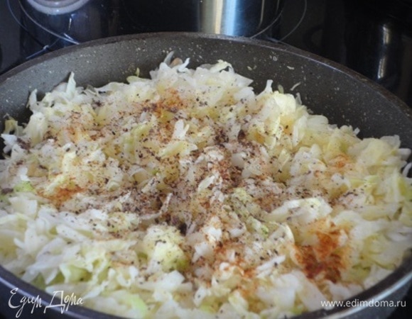 Лук нарезать мелкими кубиками и потушить на растительном масле до золотистого цвета. Добавить капусту, специи и томить под крышкой на медленном огне минут 10. Убрать с плиты и дать остыть.