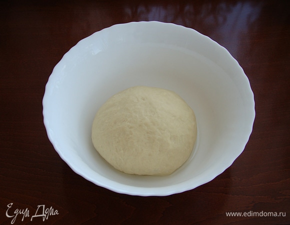 Из теста сформируйте шарик и поместите его в смазанную растительным маслом миску. Накройте салфеткой или пленкой и поставьте в теплое место, чтобы тесто поднялось. 