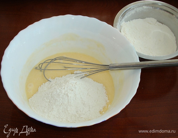 В масляную смесь частями добавьте просеянную с разрыхлителем муку, каждый раз тщательно перемешивая.