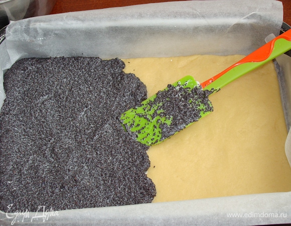 Форму для выпечки (20х30 см) застелите пергаментом. Тесто распределите равномерным слоем по дну емкости. Сверху распределите маковую начинку, предварительно добавив к ней взбитый в пышную пену яичный белок.