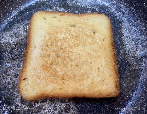 Ломтики хлеба намазать маслом, обжарить с двух сторон, выложить на тарелку.