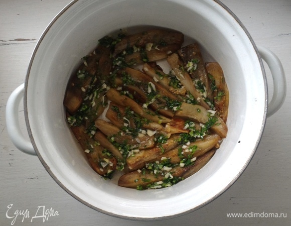 В небольшую кастрюлю выложите слой баклажанов и покройте их пряной смесью.