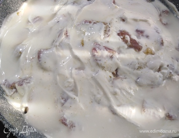 Затем свинину. Посыпать приправой. Влить подсоленную воду. Смазать мясо сметаной.