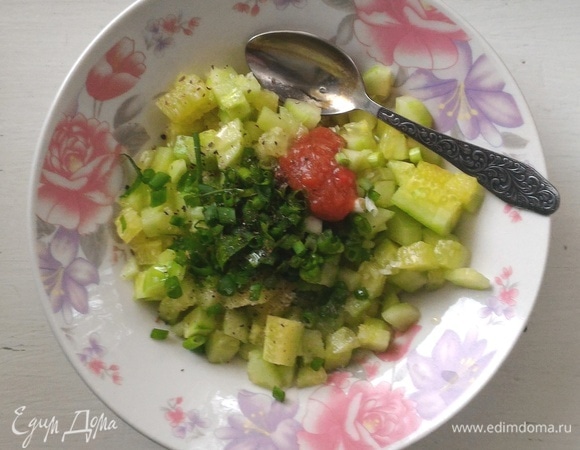 В миску выложить нарезанные огурцы и лук, добавить аджику, соль, перец, оливковое масло, лимонный сок, перемешать. Дать смеси постоять 5 минут.