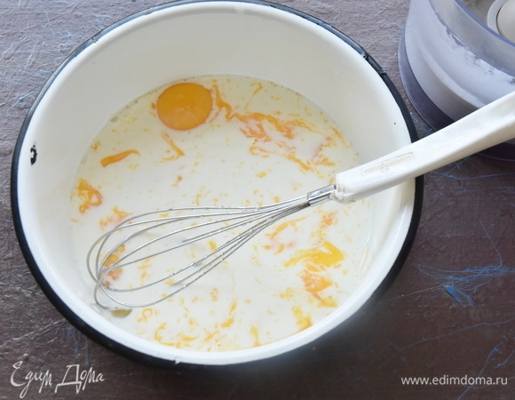 К желткам добавить молоко и перемешать венчиком. Влить растопленное сливочное масло.