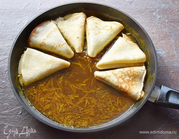 Влить апельсиновый сок. На медленном огне довести соус до нужной консистенции и растворения сахара, влить коньяк. Свернуть крепы треугольниками и уложить на сковороду с апельсиновым соусом. Прогреть с одной стороны и перевернуть. Крепы должны буквально пропитаться ароматным апельсиновым соусом. Подавать блинчики со взбитыми сливками или шариком мороженого.