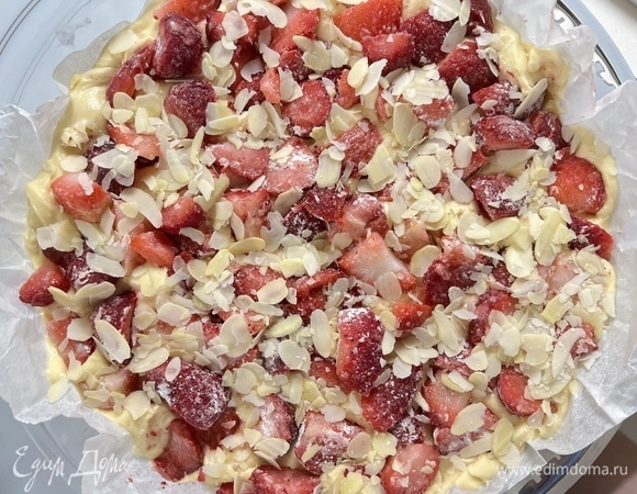 По желанию клубнику можно также посыпать сахаром и миндальными лепестками. Выпекайте при 180°C около 20 минут. Затем температуру понизьте до 160°C и оставьте в духовке еще на 30 минут. Готовность пирога проверьте деревянной шпажкой.