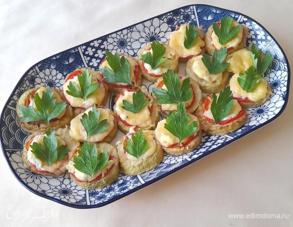 Запеченные кабачки с помидорами выложить на блюдо. Украсить листиками петрушки и подать к столу. Вкусно и в теплом, и в холодном виде. Угощайтесь! Приятного аппетита!