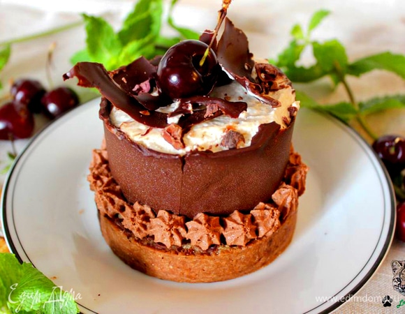 Украсьте верхушки вишней и рублеными какао-бобами. С помощью кондитерского мешка украсьте низ пирожных остатками ганаша.