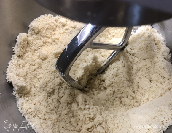 Тесто я замешивала в кухонной машине. Можно вручную. В чаше смешать муку, соль, сахар, раскрошить прессованные дрожжи, все смешать. Далее добавить нарезанное кубиками сливочное масло и перетереть смесь в крошку. Я это делала насадкой «весло».