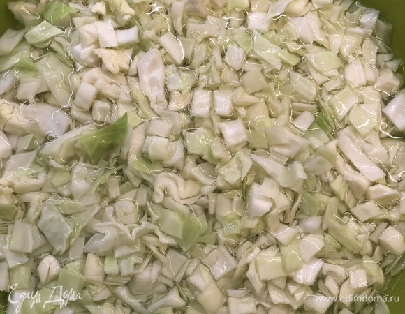 Духовку разогреть до 180°C. Пока тесто поднимается, приготовить начинку. Сварить вкрутую 2 яйца. Небольшой кочан капусты нашинковать небольшим кубиком, добавить 1 ст. л. соли, перемешать и залить кипятком так, чтобы он покрывал всю капусту, оставить на 10 минут. Воду слить.