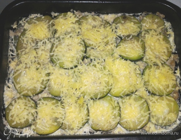 Сыр натереть на мелкой терке. Достать форму из духовки, снять фольгу, посыпать запеканку сыром. Поставить обратно в духовку до расплавления сыра.