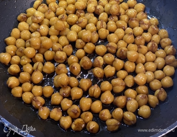 Растопить в сковороде сливочное масло. Выложить нут и обжарить на сильном огне 2–3 минуты, постоянно помешивая. Добавить соевый соус и дать нуту закарамелизироваться. Выжать сок из апельсина. Для соуса смешать оливковое масло, апельсиновый сок, соевый соус и мед. Если апельсиновый сок сладкий, то мед можно не добавлять. Можно апельсиновый сок заменить на сок лимона или грейпфрута и отрегулировать сладость при помощи меда. Слегка взбить соус до однородности (до состояния эмульсии).