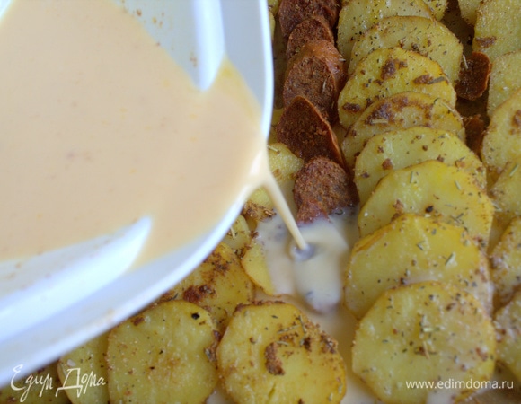 Выньте противень, полейте все взбитыми яйцами с молоком и снова уберите емкость в духовку.