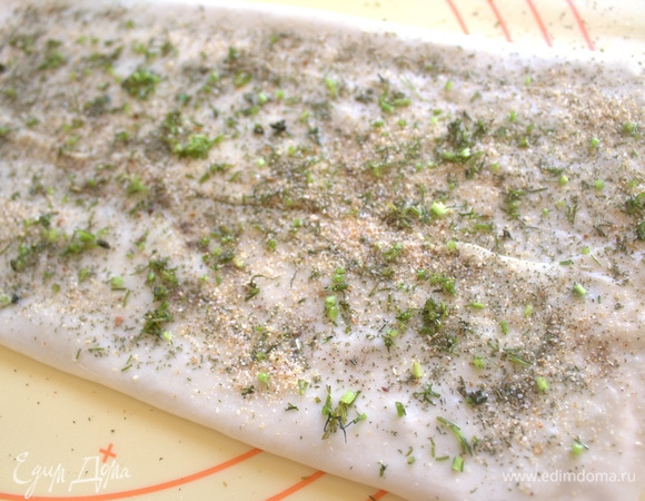 Раскатайте тонко (как на пельмени) первую часть теста, смажьте растительным маслом, посыпьте немного зеленью со специями. Затем сложите с краев к центру и снова посыпьте сухой смесью.