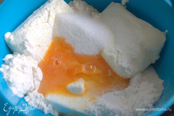 Соедините одну пачку творога с яйцом, сахаром (1–2 ст. л.) и мукой (1–2 ст. л.).