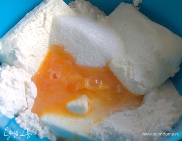 Соедините одну пачку творога с яйцом, сахаром (1–2 ст. л.) и мукой (1–2 ст. л.). 