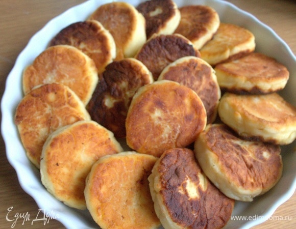 На дно можно добавить немного заливки, затем выложить сырники. 