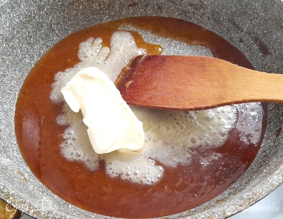 В расплавленный сахар положите сливочное масло, продолжая помешивать массу. Готовьте минуту и снимите с огня.