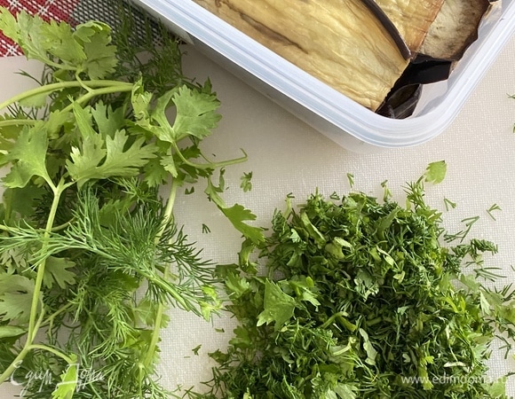 Баклажаны нарежьте вдоль тонкими полосками, посолите и отставьте на 15 минут. Затем промойте и высушите, промокнув бумажными полотенцами всю жидкость. Обжарьте баклажаны на растительном масле до румяной корочки. Выложите их на бумажные полотенца для удаления лишнего масла или запеките в духовке при температуре 180°C на пергаменте, смазав кусочки растительным маслом. В процессе я переворачивала несколько раз, смазывая маслом ломтики при помощи кисточки. По времени это значительно дольше, чем жарить на сковороде, но меньше масла впитывается точно.