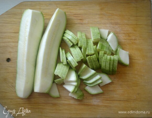 Кабачок вымойте и обсушите. Разрежьте овощ вдоль на четыре части и нарежьте его тонкими пластинами