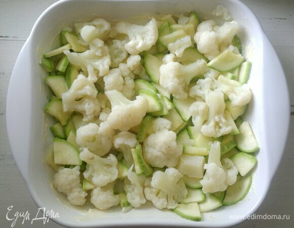 Форму для запекания смажьте холодным сливочным маслом. Выложите в форму кабачки, сверху — цветную капусту.