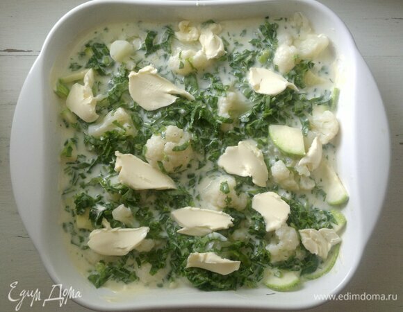 На овощи вылейте заливку. Масло разделите на небольшие кусочки и выложите сверху. Поставьте запеканку в духовку, разогретую до 180°C на 35–40 минут.