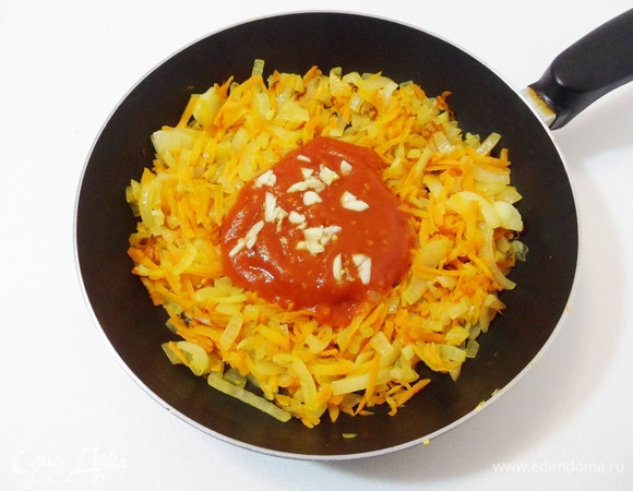 Затем добавить к овощам кетчуп (или измельченные томаты), по желанию также — дольки чеснока. Тушить около 5 минут под крышкой на медленном огне.