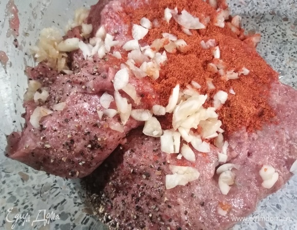 В фарш добавить паприку, измельченный чеснок, перец, соль. Перемешать.
