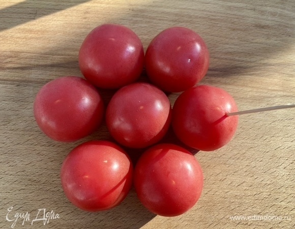 Мелкие томаты наколоть шпажкой. Одну головку чеснока разрезать поперек. Вторую очистить и пропустить зубцы через пресс. Соединить оливковое масло, чеснок и лимонный сок, приправить солью и перцем.