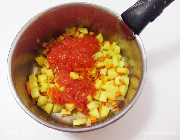 Добавить в кастрюлю картофель, нарезанный брусочками, и обжаривать его около 5 минут. Затем заложить в кастрюлю нарезанные помидоры и обжарить еще несколько минут.
