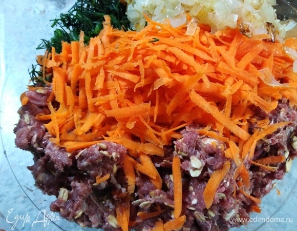 В фарш высыпьте промытый геркулес и перемешайте. Головку лука обжарьте, соедините с фаршем. Затем добавьте половину натертой моркови и зелень, посолите.