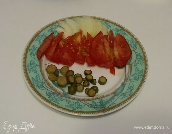 Для начала нужно подготовить овощи. Репчатый лук нарезать полукольцами. Помидор нарезать дольками, а каперсы — кружочками.