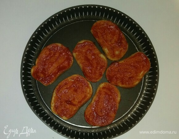 На противень (не смазывая его маслом) выложить тосты и смазать их протертыми помидорами.