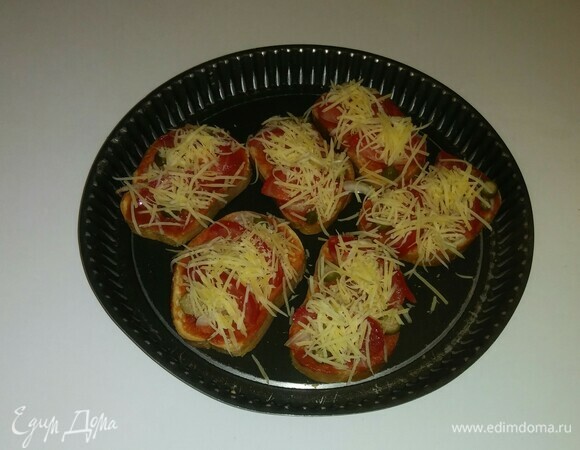 Посыпать тосты сыром. Разогреть духовку до 180°C и поставить в нее противень на 5 минут (время приготовления зависит от вашей духовки).