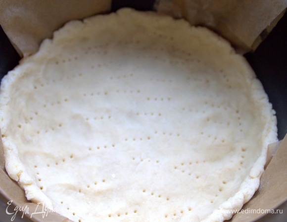 Скатать в шар, расплющить, перенести в чашу мультиварки, постелив смазанный пергамент (вырезать две широкие полоски с длинными концами, чтобы удобнее было вытаскивать), и размять по дну с бортиками. Наколоть дно вилкой.