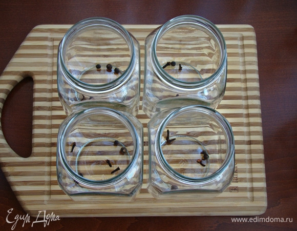 В сухие стерилизованные банки (0,7 л) уложите по 3 бутона гвоздики и по 3 горошины душистого перца.