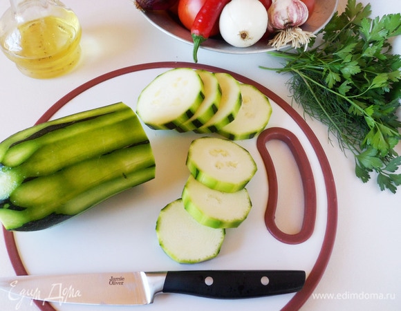 Вымойте кабачки и помидоры. Нарежьте их кружочками не более 1 см толщиной.