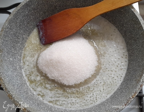 Выложить в сковороду сахар и продолжать нагревать, помешивая.