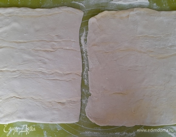 Слоеное тесто достать из морозилки. Разморозить при комнатной температуре. Раскатать 2 квадратных пласта. Дать подойти, примерно 1 час, время зависит от температуры на кухне. У меня тесто было в рулоне и при разворачивании немного повредилось на сгибах. В следующий раз тесто этого производителя не буду покупать. Лучше всего взять тесто в пластах.